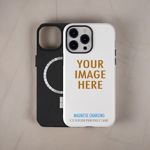 May include: A white phone case with the gold text YOUR IMAGE HERE and black text MAGNETIC CHARGING CUSTOM PHONE CASE, positioned in front of a black phone case featuring a circular magnetic charging ring on the back surface.