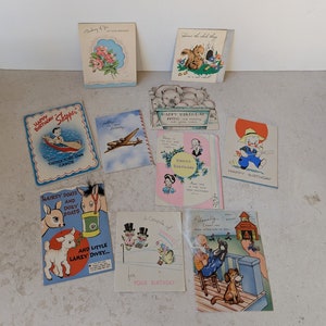 May include: A collection of vintage birthday cards with various illustrations and messages. The cards feature colorful designs, including animals, people, and whimsical scenes. The cards are printed on thick paper and have a textured finish.