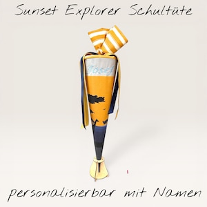 Könnte beinhalten: Eine kegelförmige Schultüte mit Sonnenuntergangsdesign. Die Tasche ist gelb und orange mit einer schwarzen Silhouette einer Landschaft. Die Oberseite ist mit einer gestreiften Schleife gebunden. Der Text "Sunset Explorer Schultüte" und "personalisierbar mit Namen" sind sichtbar.