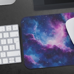May include: A blue and purple galaxy-themed mousepad with a white computer mouse on top of it.