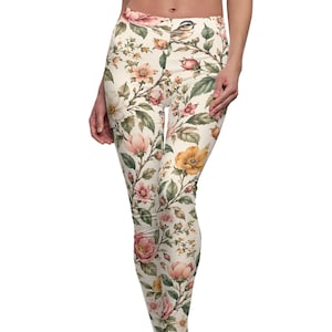 May include: Full-length leggings featuring an off-white base color with a detailed botanical print. The pattern includes various blooming flowers in shades of pink, yellow, and orange, interspersed with green leaves and small birds.