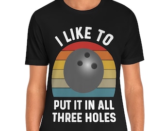 May include: A black t-shirt with a retro-style graphic of a bowling ball and the text "I like to put it in all three holes".