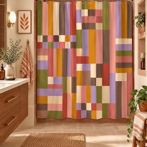 May include: A shower curtain featuring a geometric pattern of vertical and horizontal rectangular blocks in shades of mustard yellow, olive green, dusty pink, lavender, cream, and dark brown, suspended from a metal rod with silver rings.