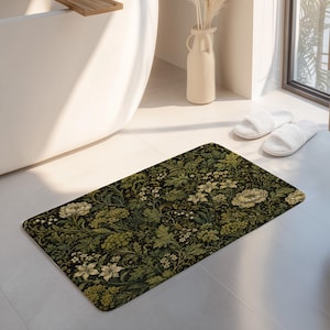 May include: A rectangular bath mat featuring a dense, intricate botanical pattern with cream-colored flowers and various shades of green foliage set against a dark, near-black background. The design covers the entire surface of the mat.