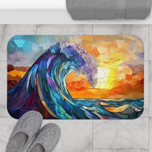 May include: A rectangular bath mat featuring a stained glass style illustration of a large ocean wave crashing against a sunset sky. The design incorporates shades of deep blue, teal, and purple in the water, contrasted by vibrant orange and yellow hues in the sky, all segmented by dark lines.