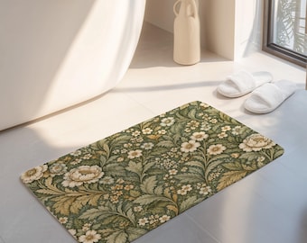 Puede incluir: Una alfombrilla de baño rectangular con un denso patrón botánico de flores color crema y follaje verde intrincado. El diseño muestra hojas y flores superpuestas en tonos de salvia, oliva y verde bosque oscuro sobre una superficie texturizada.