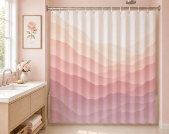 Puede incluir: Una cortina de ducha con un patrón abstracto ondulado y superpuesto en tonos degradados de blanco, crema, melocotón, rosa suave y rosa polvoriento. La cortina cuelga de una barra de metal plateado con anillos circulares.