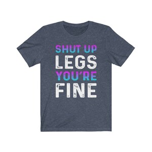 May include: A dark blue t-shirt with the text "SHUT UP LEGS YOU'RE FINE" in white with a gradient of pink and blue.