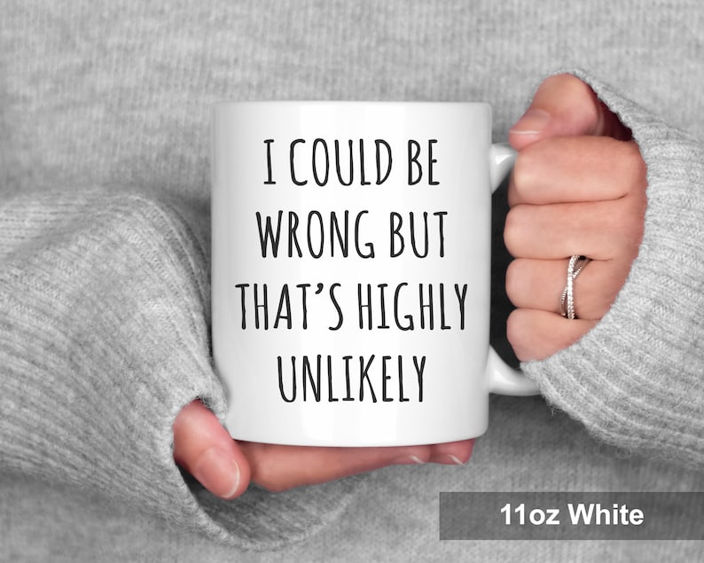May include: White ceramic mug with the text "I COULD BE WRONG BUT THAT'S HIGHLY UNLIKELY" in black. The mug is held by a person wearing a gray sweater. The mug is labeled "11oz White".
