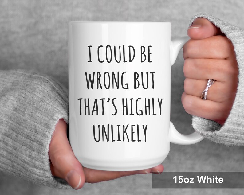 May include: A white ceramic mug with the text "I COULD BE WRONG BUT THAT'S HIGHLY UNLIKELY" in black. The mug has a curved handle and the text "15oz White" is printed at the bottom.