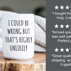 May include: White ceramic mug with the text "I COULD BE WRONG BUT THAT'S HIGHLY UNLIKELY" in black. The mug has a curved handle and is on a wooden surface. Customer reviews with star ratings are visible in the background.