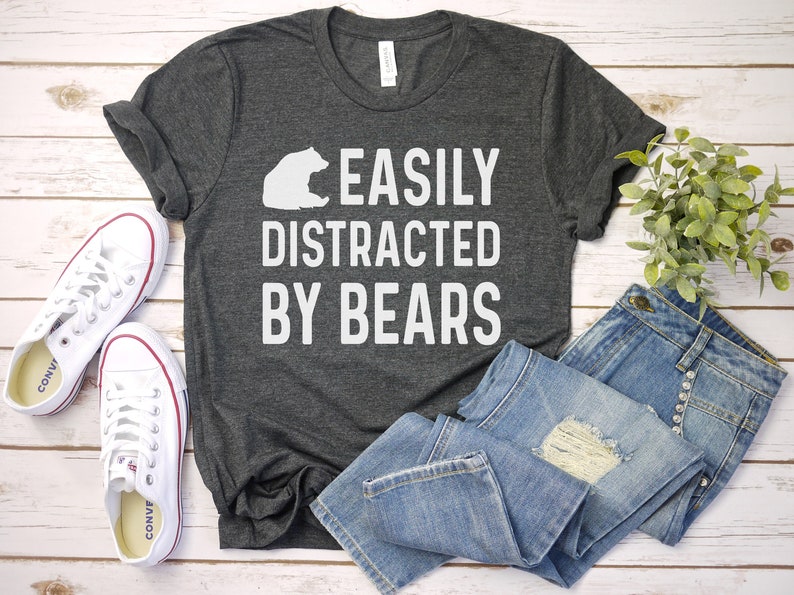 May include: A dark gray t-shirt with a white bear graphic and the text "EASILY DISTRACTED BY BEARS".
