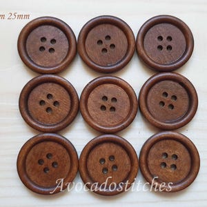 May include: Eight brown wooden buttons with four holes each. The buttons are 23mm and 25mm in diameter.