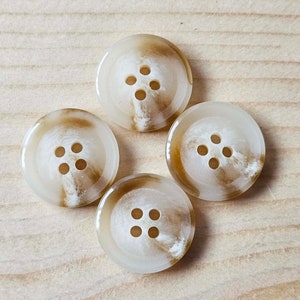 May include: Four white and brown swirl buttons with four holes each.