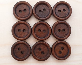 May include: Nine brown wooden buttons with two holes each. The buttons are arranged in three rows of three.