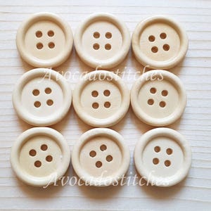 May include: Ten round wooden buttons with four holes each. The buttons are a light beige colour.