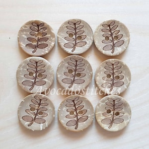 May include: Eight brown coconut buttons with a leaf design. The buttons are approximately 1 inch in diameter.
