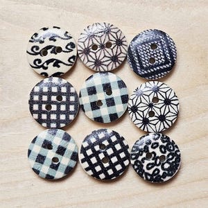 May include: Eight round wooden buttons with black and white patterns. The patterns include gingham, geometric shapes, and floral designs.
