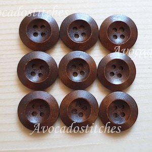 May include: Ten brown wooden buttons with four holes each. The buttons are round and have a slightly raised centre.