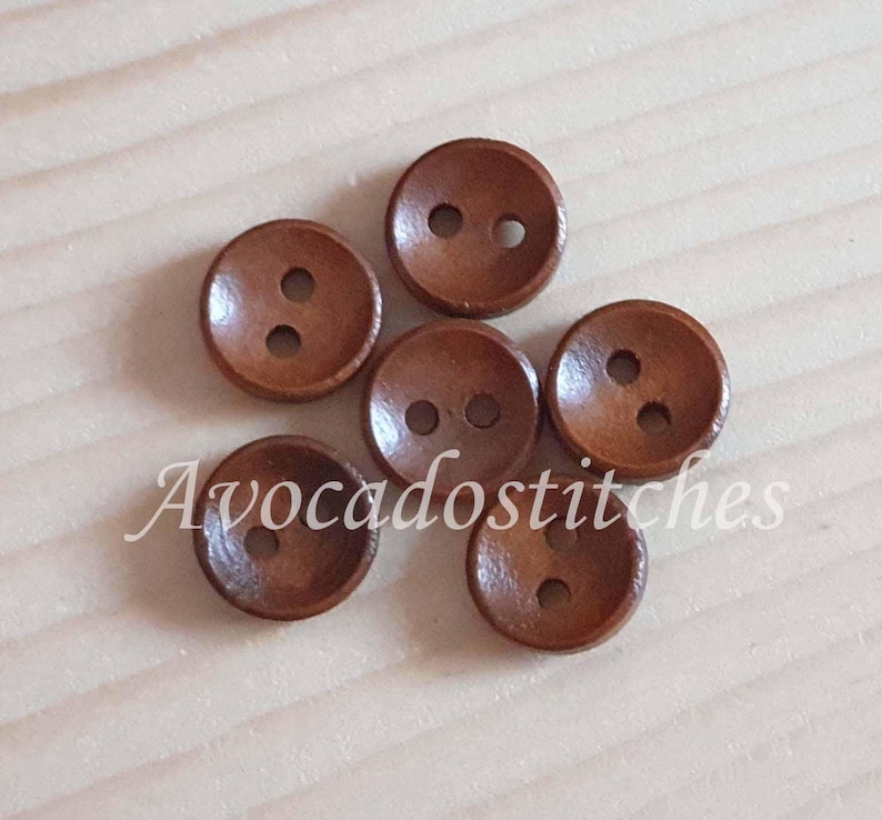 May include: Six brown wooden buttons with two holes each. The buttons are arranged in a circle.