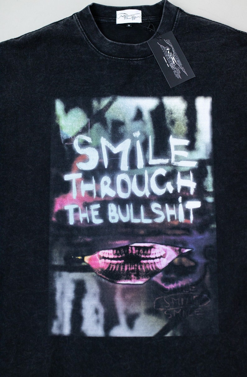May include: Black t-shirt with a graphic print of a mouth with teeth and the text "Smile Through The Bullshit".