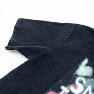 May include: Black t-shirt with a faded graphic print that says "Smile Through The Pain".