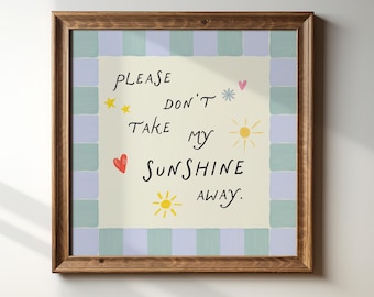May include: A framed print with a light yellow background and blue and white checkered border. The print features a handwritten message that says "Please don't take my sunshine away." The message is surrounded by hand-drawn hearts, stars, and suns.