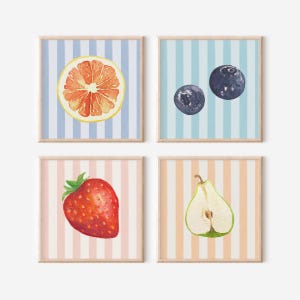 Puede incluir: Cuatro impresiones de arte de pared imprimibles con ilustraciones de acuarela de frutas sobre un fondo a rayas. Las impresiones presentan una toronja, dos arándanos, una fresa y una pera.