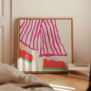 以下が含まれることがあります： クリーム色の背景に鮮やかなピンクの縦縞が入ったワイドパンツを履いた脚と、水色の靴紐と緑色のソールが付いた鮮やかな赤色のスニーカーを描いた、正方形の額入りウォールアートプリント。