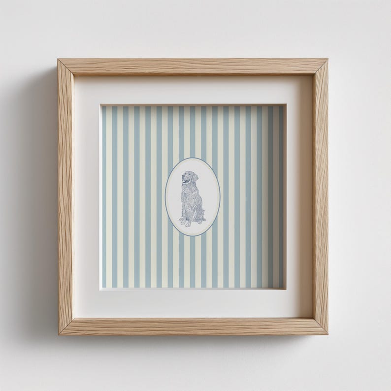 May include: A framed print featuring a seated dog illustration within an oval frame. The background has vertical stripes in light blue and off-white. The frame is made of light-colored wood.