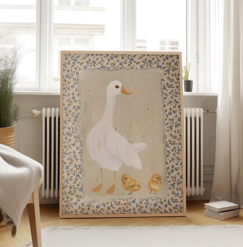 Peut inclure: Une illustration encadr&eacute;e d'une oie blanche avec deux oisons jaunes. Le cadre a un motif floral avec des fleurs bleues et vertes.