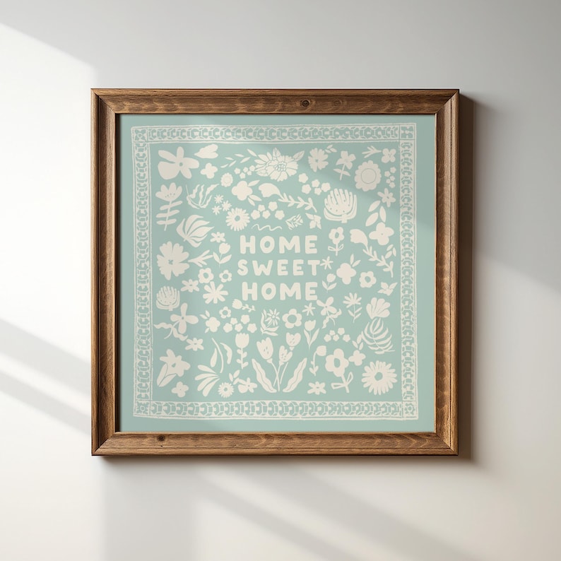 May include: A framed print with a light blue background and white floral pattern. The text "Home Sweet Home" is centered in the design.