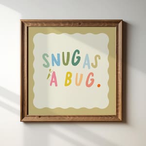 Peut inclure: Une impression encadrée avec un cadre brun clair et un fond blanc. L'impression présente le texte "Snug as a bug." en lettres colorées avec une petite illustration d'un insecte vert.