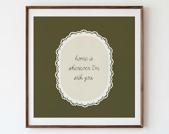 May include: A square wall art print in a dark olive green frame featuring a cream-colored oval center with a white scalloped lace border. The text in the center reads, Home is wherever I'm with you, written in a dark brown cursive script font.
