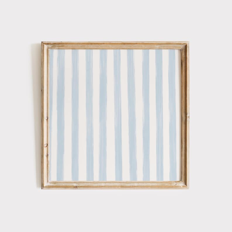 May include: A framed artwork with a blue and white striped pattern. The frame is a light wood color.