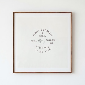 May include: A square wall art piece featuring a dark brown wooden frame and a white background. The center displays black text arranged in a circular pattern that reads: SURELY GOODNESS & MERCY WILL FOLLOW ME ALL THE DAYS OF MY LIFE, with a small bird.