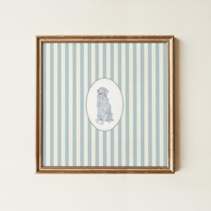May include: Framed artwork featuring a seated dog illustration within an oval frame. The dog is depicted in a detailed, monochromatic style. The background has vertical stripes in light blue and off-white, encased in a gold-colored frame.