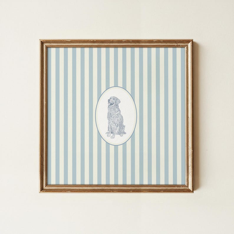May include: Framed artwork featuring a seated dog illustration within an oval frame. The dog is depicted in a detailed, monochromatic style. The background has vertical stripes in light blue and off-white, encased in a gold-colored frame.