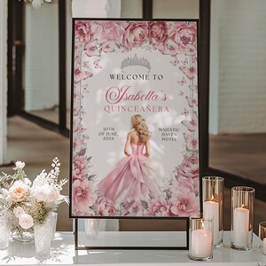 May include: A pink and white welcome sign with floral accents and butterflies. The sign reads "Welcome to Isabella's Quincea&ntilde;era" with the date "30th of June, 20XX" and the location "Majestic Haven Hotel".