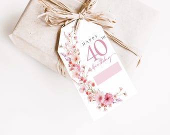 Puede incluir: Una etiqueta de regalo blanca con diseños florales rosas y el texto "Feliz cumpleaños número 40".
