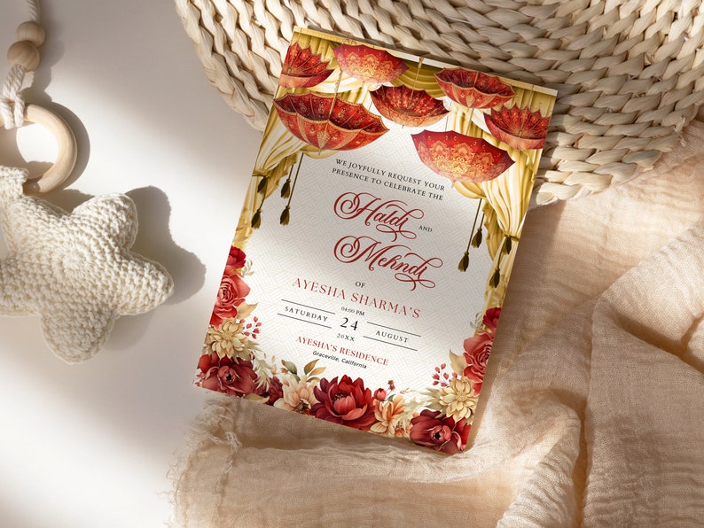 K&ouml;nnte beinhalten: Eine Hochzeitseinladung mit einem floralen Design mit roten und goldenen Blumen. Der Einladungstext lautet: "Wir bitten Sie herzlich, an der Feier des Haldi und Mehndi von Ayesha Sharma teilzunehmen, am Samstag, den 24. August 20xx, in Ayeshas Residenz, Greenville, Kalifornien."