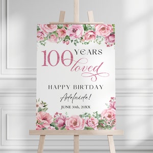 Puede incluir: Un cartel blanco con un borde floral rosa y el texto "100 Years Loved" en purpurina rosa. El cartel también dice "Happy Birthday Adelaide! June 30th, 20XX".