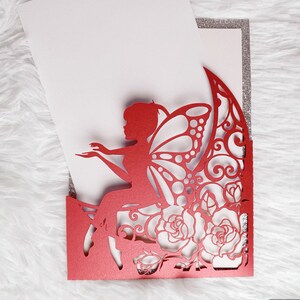 May include: Red laser cut invitation with a fairy sitting on a rose with butterfly wings. The invitation has a silver glitter border.