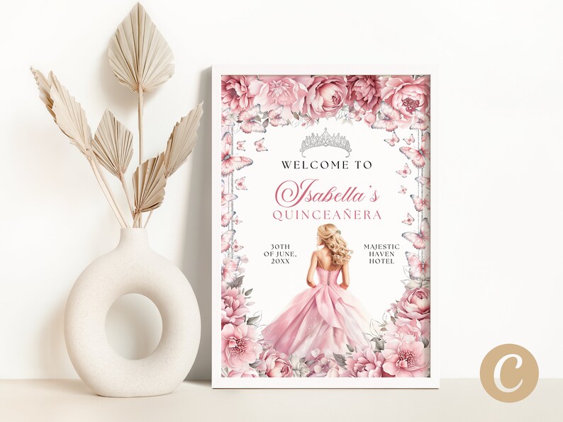 May include: A white framed poster with a pink floral border and butterflies. The text reads "Welcome to Isabella's Quincea&ntilde;era" with the date "10th of June, 20XX" and the location "Majestic Haven Hotel".