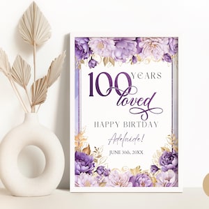 May include: Purple and gold floral birthday sign with the text "100 Years Loved" and "Happy Birthday Adelaide! June 30th, 20XX".