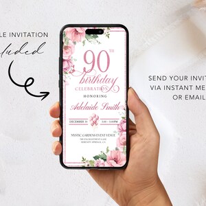 Peut inclure: Une invitation mobile pour un 90e anniversaire avec des fleurs roses et blanches. L'invitation comprend le texte "90e anniversaire c&eacute;l&eacute;bration en l'honneur d'Adelaide Smith" ainsi que la date et l'heure de l'&eacute;v&eacute;nement.