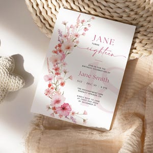 May include: A pink and white floral invitation for an 18th birthday party. The invitation reads "Jane turns eighteen" and includes the text "Join us for the birthday celebration of Jane Smith, Sat Dec 30, 6 PM, 789 Enchantment Lane, Serenity Springs, CA. Kindly RSVP to Jane at (000) 000-0000 by December 15."