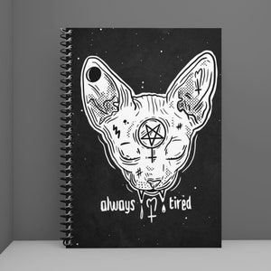 May include: Black and white illustration of a sphinx cat with a pentagram and other symbols on its head. The text "always tired" is below the cat.