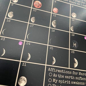 May include: A black calendar with a grid layout, featuring moon phase illustrations and astrological symbols. The calendar includes dates and affirmations for March. The background has a starry night design.