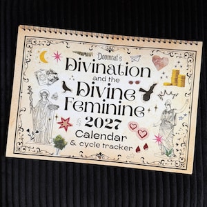 May include: A spiral-bound 2027 calendar and cycle tracker titled Doomcat's Divination and the Divine Feminine. The cover features a beige background with black text, illustrations of two classical figures, tarot cards, coins, stars, and hearts.